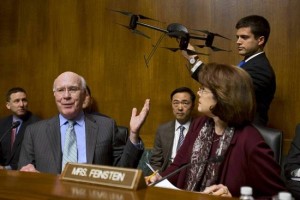 Senate Judiciary Committee Chairman Sen. Patrick Leahy, D-Vt., left, gestures to an example of a drone held by a staff member, on Capitol Hill in Washington, Wednesday March 20, 2013, during the committee's hearing to examine the future of drones in America, focusing on law enforcement and privacy considerations. At right is Sen. Dianne Feinstein, D-Calif. (AP Photo/Jacquelyn Martin)