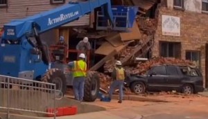 Crews work to remove rubble from collapsed building.